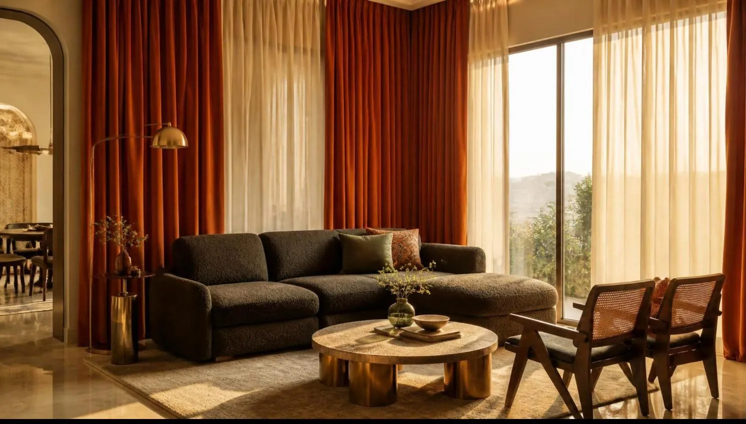 Living room with floor-to-ceiling rust velvet curtains over ivory sheers and a charcoal sofa